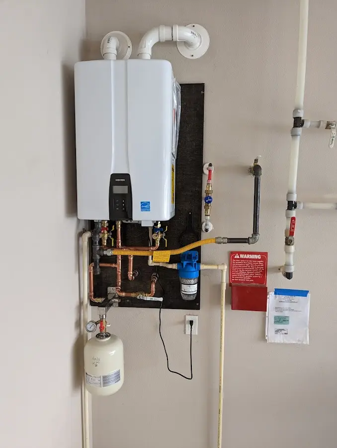 Professional plumber installing copper piping in a Johnston City home